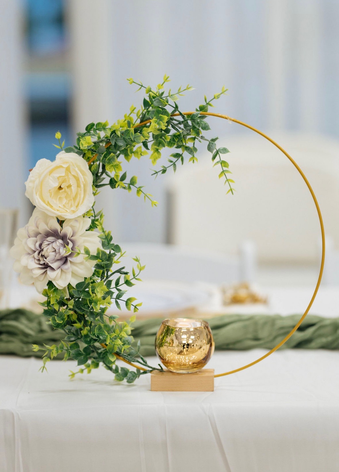 Guest taking a photo in front of a cream, green, and gold balloon backdrop with Happy Birthday sign.